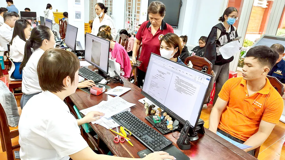 Chuyên viên Trung tâm Phục vụ hành chính công phường Đông Hòa tiếp và giải quyết thủ tục hành chính của người dân. Ảnh: THU HƯỜNG