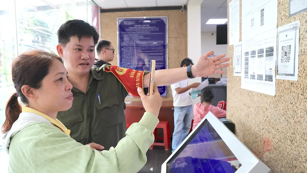 Lực lượng tham gia bảo vệ an ninh, trật tự ở cơ sở và cán bộ phường luôn túc trực để hướng dẫn người dân cài đặt ứng dụng