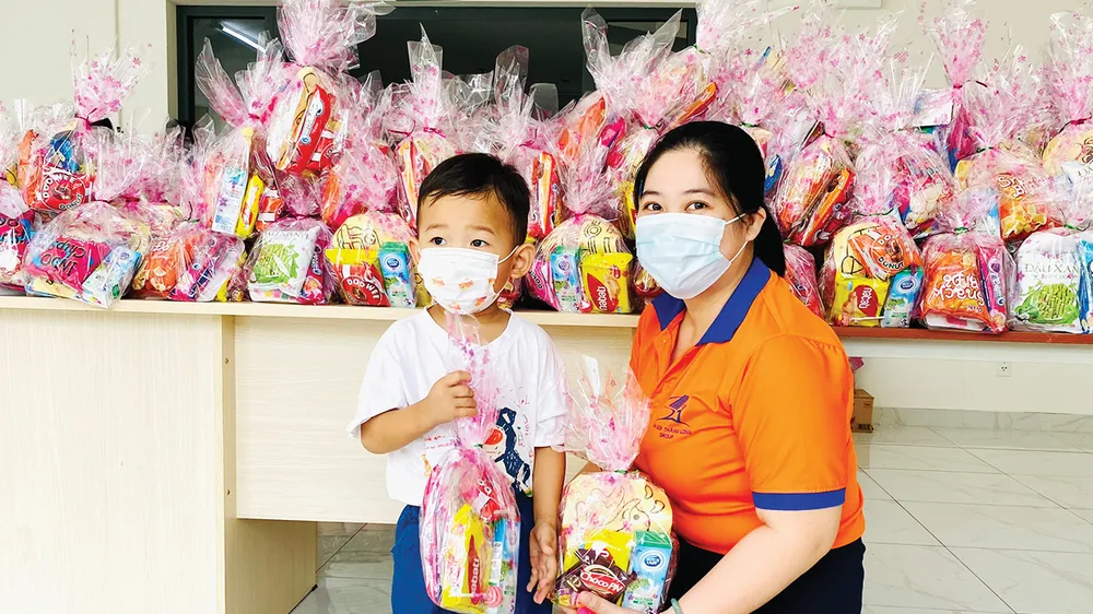 Các bé nhận quà được đeo khẩu trang, sát khuẩn kỹ càng