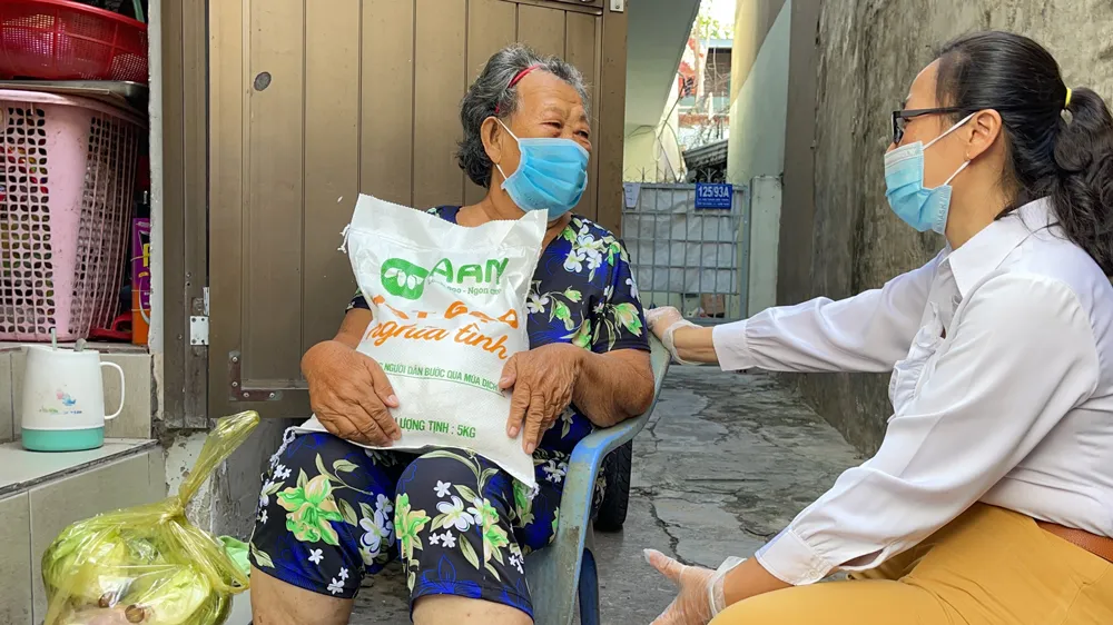 Xe gạo nghĩa tình đến với người dân khó khăn ở phường 3, quận Bình Thạnh. Ảnh: HOÀNG HÙNG