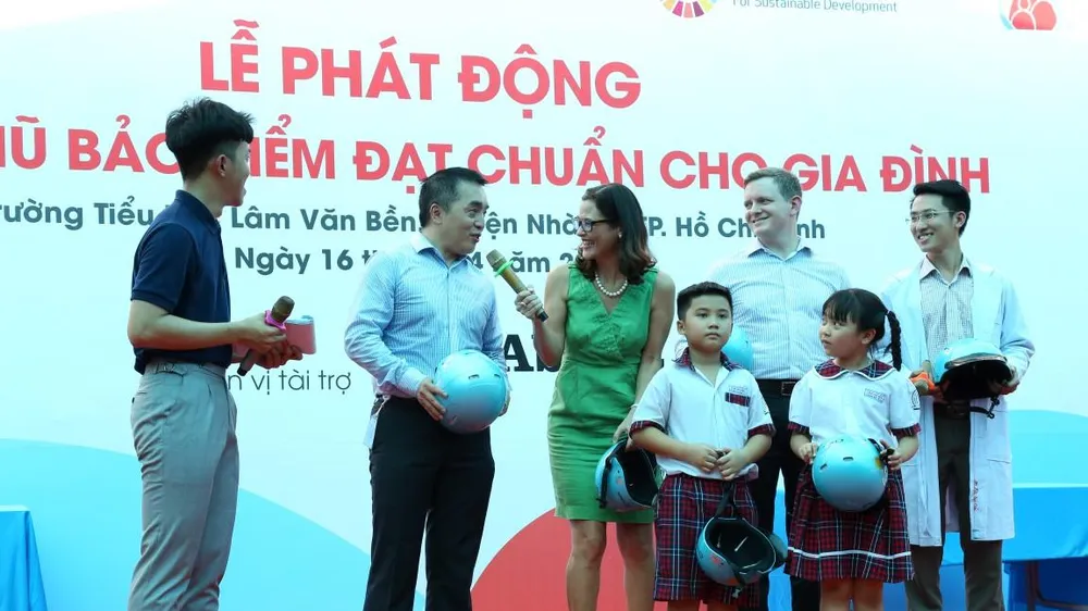 Học sinh được hướng dẫn cách đội nón bảo hiểm tại lễ phát động