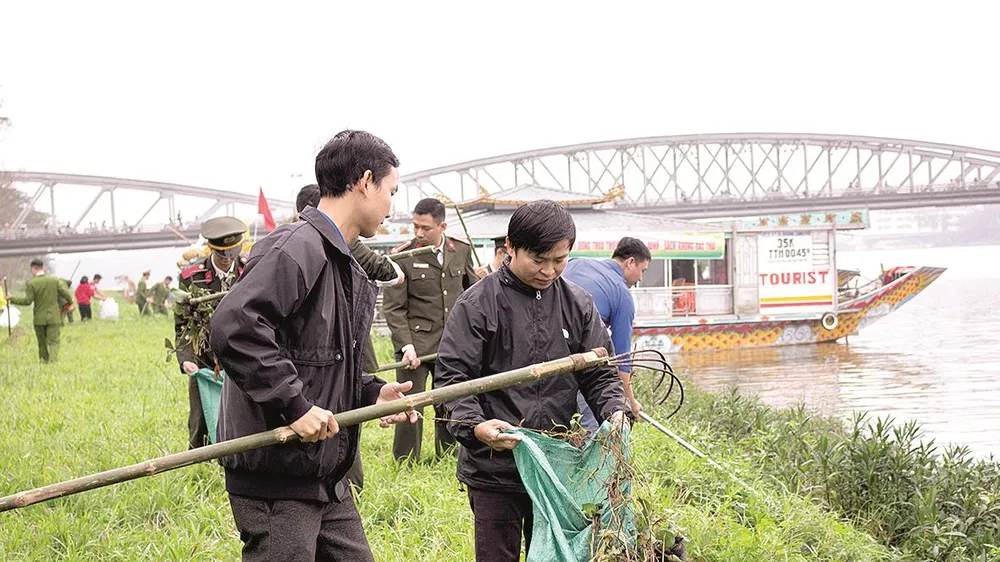  Công an tỉnh Thừa Thiên- Huế cùng sinh viên dọn rác và vớt bèo dọc bờ sông Hương
