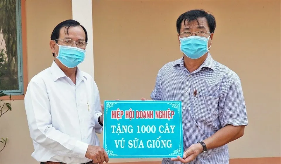 Chủ tịch Hiệp hội Doanh nghiệp tỉnh, ông Lê Hoàng Phước (trái) đại diện trao bảng tượng trưng 1.000 cây vú sữa giống tặng UBND xã Trí Lực. Ảnh: Báo Cà Mau