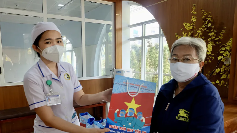Đảng viên cao tuổi và người dân tới thăm khám hậu mắc Covid-19 được nhận quà của chương trình