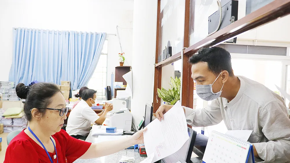 Công chức phường Bình Hưng Hòa A, quận Bình Tân, TPHCM tiếp nhận giải quyết thủ tục hành chính cho người dân. Ảnh: NGÔ BÌNH