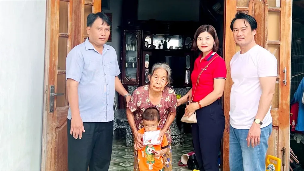 Đại diện Báo Sài Gòn Giải Phóng trao số tiền bạn đọc hỗ trợ cho gia đình bà Nguyễn Thị Lâm (ẢNH: TRÚC GIANG)