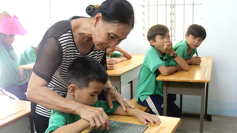 Cô nắn nót từng nét chữ cho học trò