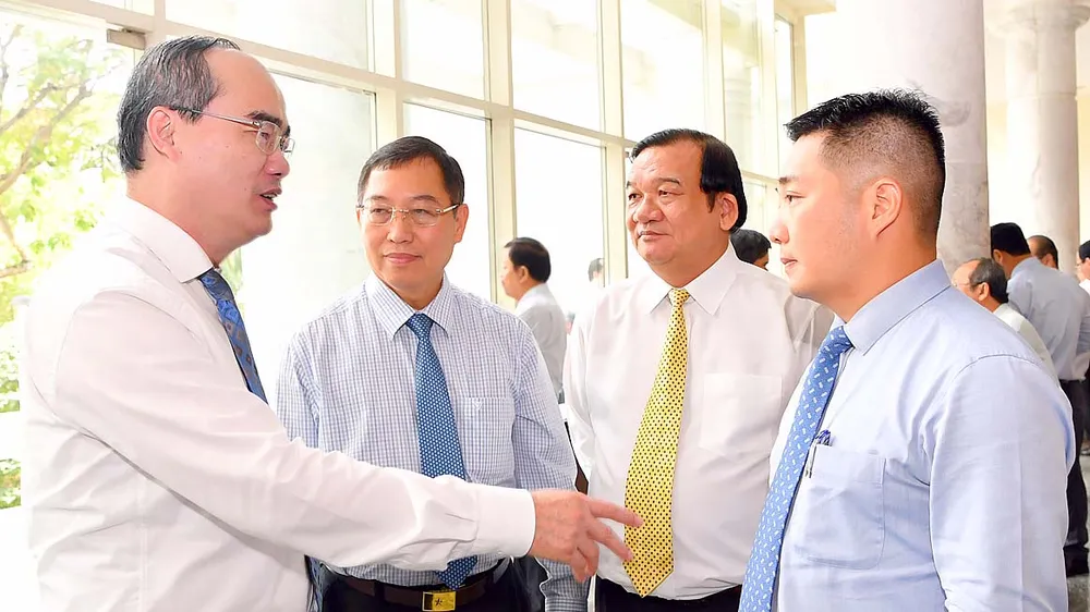 Bí thư Thành ủy TPHCM Nguyễn Thiện Nhân trao đổi cùng các đại biểu tại Hội nghị Thành ủy . Ảnh: VIỆT DŨNG