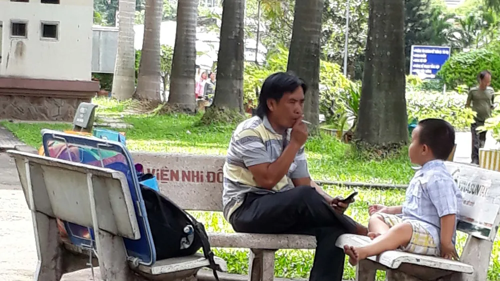  Cảnh thản nhiên hút thuốc ngay trong Bệnh viện Nhi đồng 2 . Ảnh: THU HƯỜNG