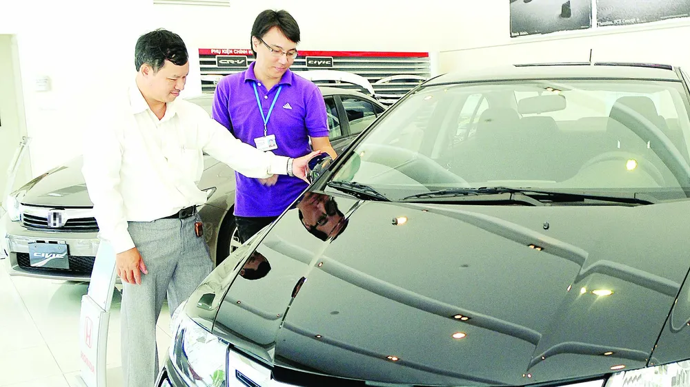 Khách tham quan một salon ô tô ở TPHCM. Ảnh: CAO THĂNG