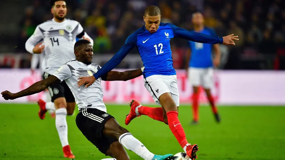 Kylian Mbappe (Pháp, bên phảoi) đi bóng qua trung vệ Rudiger (Đức)