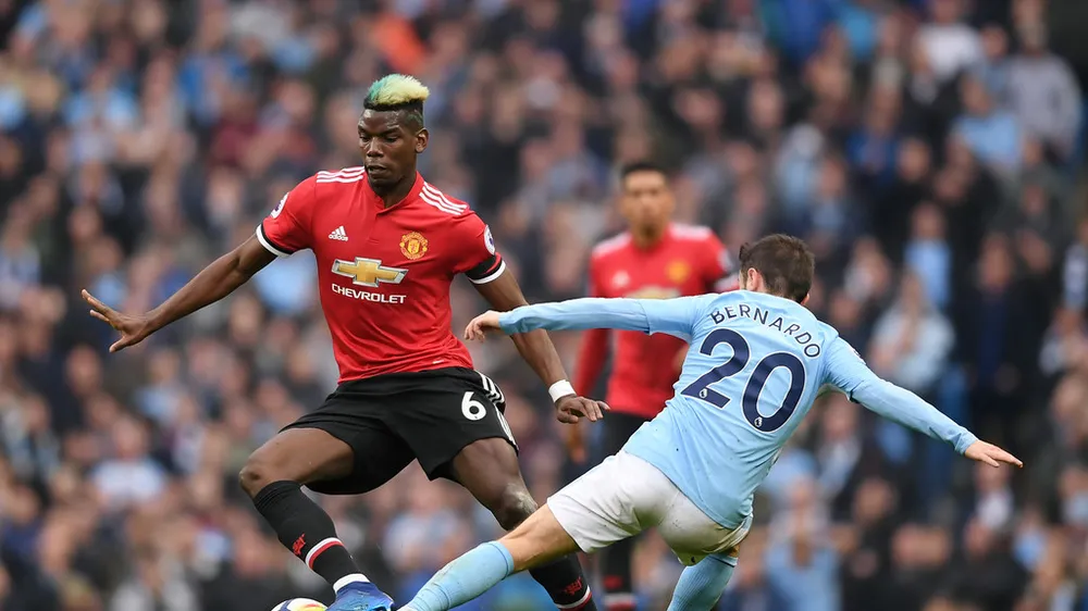 Paul Pogba (Man United, trái) đi bóng qua Bernardo Silva (Man City)
