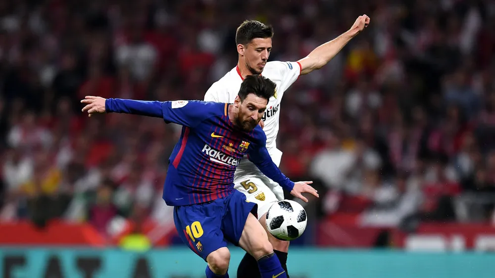 Lio Messi đi bóng qua hậu vệ Sevilla