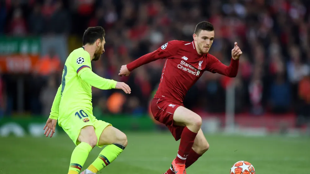 Andy Robertson (phải) cố gắng đi bóng qua Lionel Messi