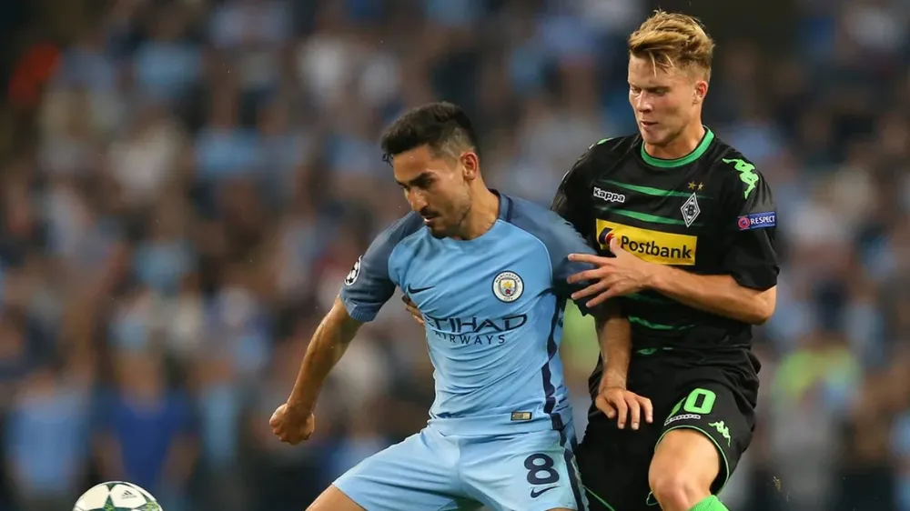 Ilkay Gundogan (trái, Manchester City) tranh bóng với Nico Elved (Borussia Mönchengladbach)
