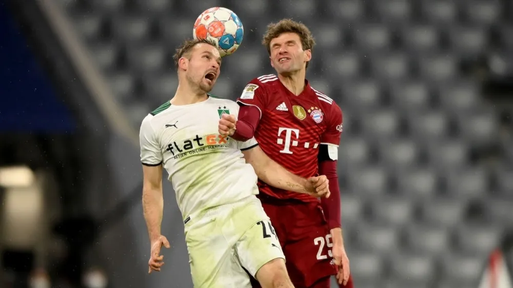 Thomas Muller tranh bóng với hậu vệ Gladbach
