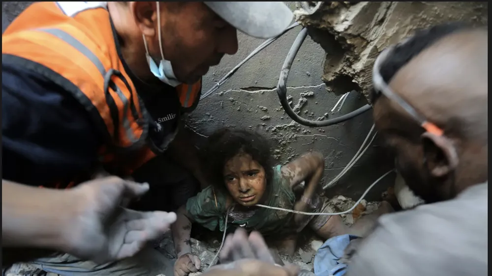 Người Palestine cứu một cô gái ra khỏi đống đổ nát của tòa bị phá hủy bởi cuộc không kích của Israel ở trại tị nạn Jabaliya, phía bắc Dải Gaza. Ảnh: AP 