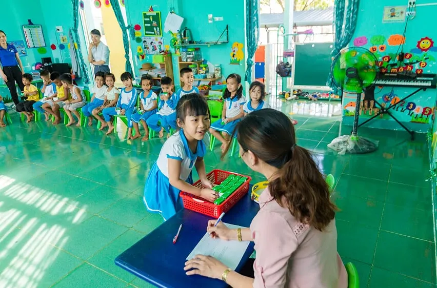 Các em học sinh trường Tiểu học thực hành thao tác gấp vỏ hộp sau khi uống sữa