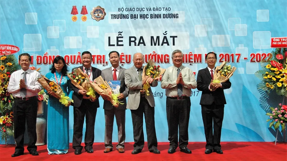 Ông Đặng Minh Hưng (thứ 2, từ phải) tặng hoa chúc mừng Ban Giám hiệu