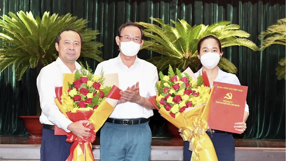 Bí thư Thành ủy TPHCM Nguyễn Văn Nên trao quyết định cho đồng chí Vũ Hải Quân và đồng chí Lê Thị Hờ Rin. Ảnh: VIỆT DŨNG