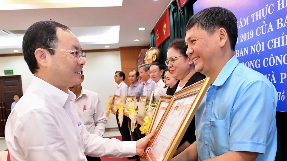 Phó Bí thư Thành ủy TPHCM Nguyễn Văn Hiếu trao bằng khen cho các tập thể. Ảnh: VIỆT DŨNG
