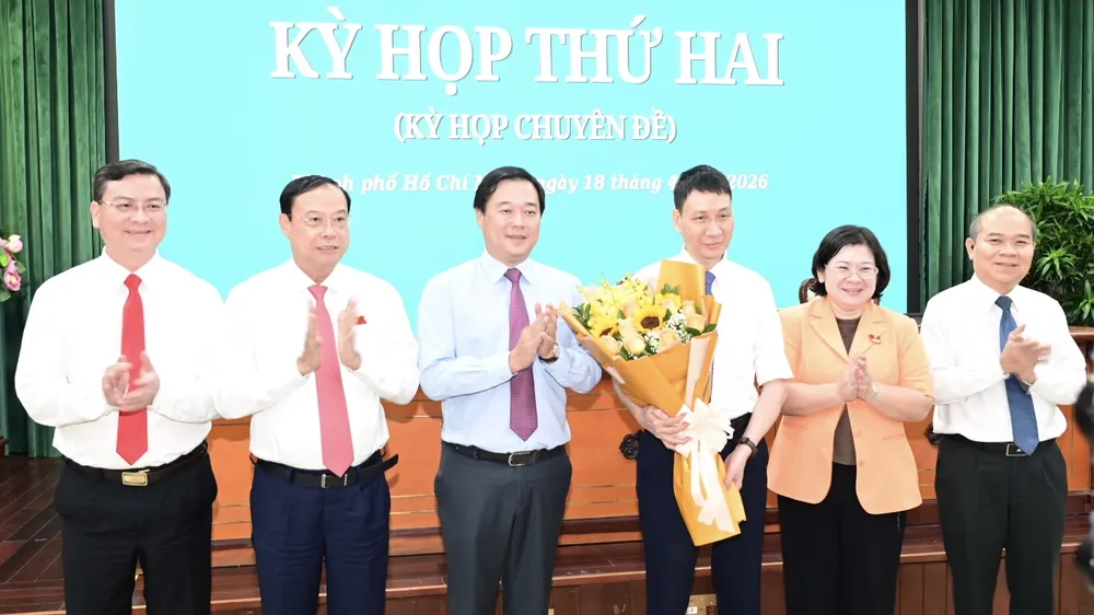 Phó Bí thư Thường trực Thành ủy TPHCM Lê Quốc Phong, Phó Bí thư Thành ủy TPHCM Văn Thị Bạch Tuyết và lãnh đạo HĐND TPHCM, UBND TPHCM tặng hoa chúc mừng ông Trương Trung Kiên. Ảnh: VĂN MINH