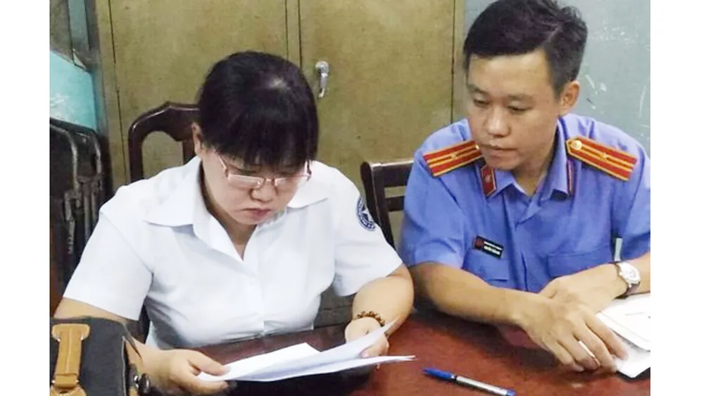Nguyên chấp hành viên Đinh Thị Anh Đào (trái) lúc bị bắt 