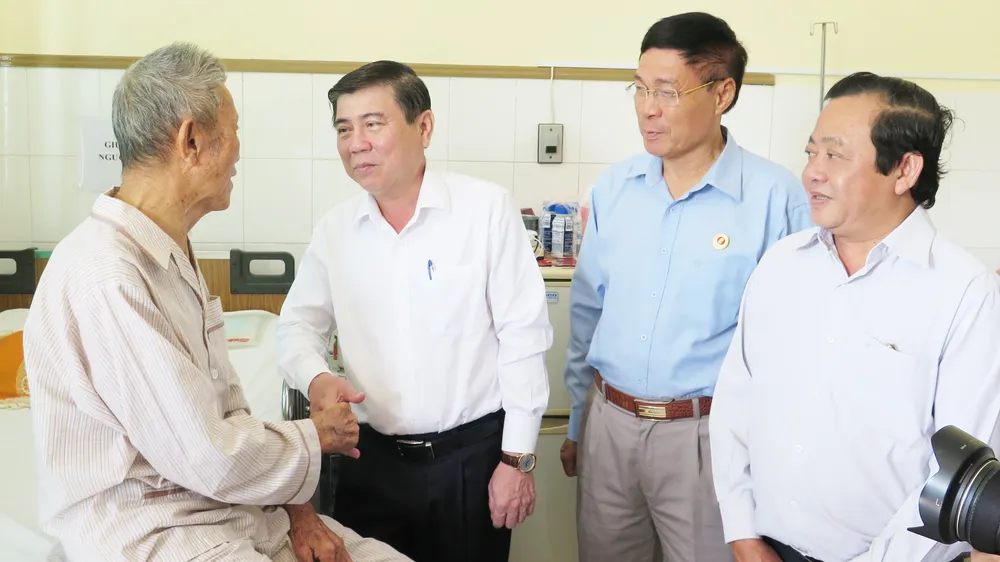 Chủ tịch UBND TPHCM Nguyễn Thành Phong ân cần thăm hỏi đồng chí Trần Tài Ba. Ảnh: KIỀU PHONG