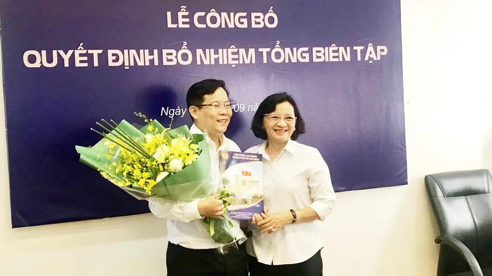 Đồng chí Thân Thị Thư, Trưởng Ban Tuyên giáo Thành ủy TPHCM, tặng hoa chúc mừng tân Tổng Biên tập Báo Người Lao động Tô Đình Tuân. Ảnh: KIỀU PHONG