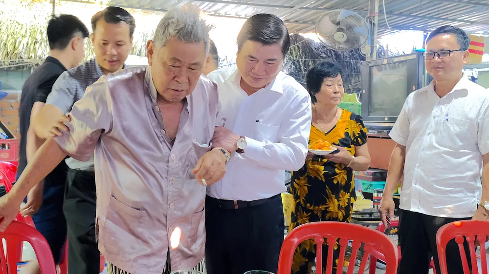 Chủ tịch UBND TPHCM ân cần thăm hỏi sức khỏe ông Huỳnh Quang Hải và gia đình ông. Ảnh: KIỀU PHONG 