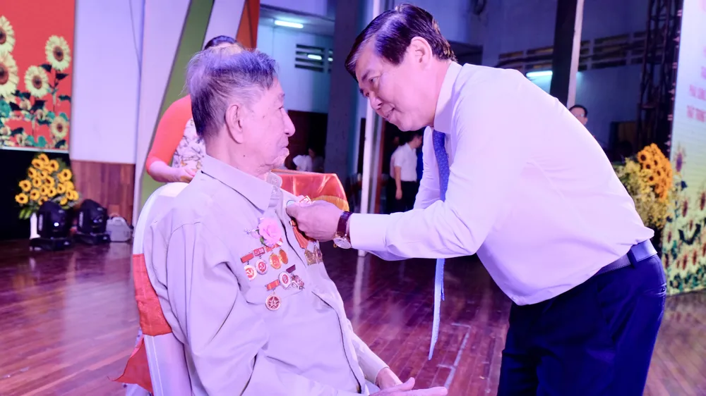 Đồng chí Nguyễn Thành Phong trao Huy hiệu 70 năm tuổi Đảng cho Đảng viên Quận Thủ Đức. Ảnh: KIỀU PHONG