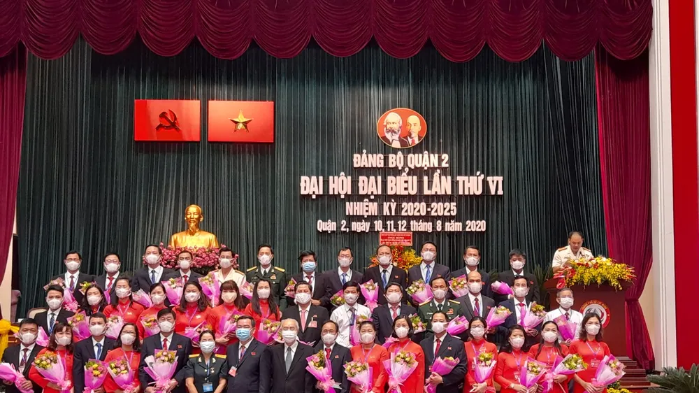 Đồng chí Huỳnh Đảm, nguyên Ủy viên Trung ương Đảng, nguyên Chủ tịch Ủy ban Trung ương MTTQ Việt Nam và đồng chí Trần Văn Thuận, Bí thư Quận ủy quận 2 nhiệm kỳ 2015-2020, tặng hoa chúc mừng Ban Chấp hành Đảng bộ quận 2 khoá mới. Ảnh: VĂN THÀNH 