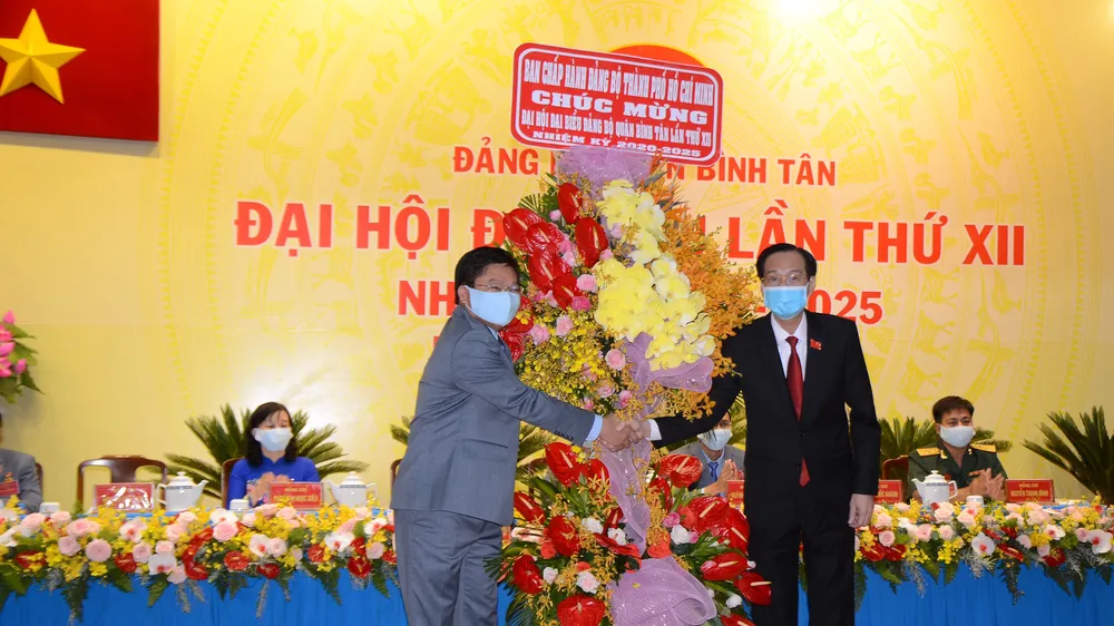 Phó Chủ tịch Thường trực UBND TPHCM Lê Thanh Liêm tặng hoa, chúc mừng Đại hội đại biểu Đảng bộ quận Bình Tân. Ảnh: KIỀU PHONG