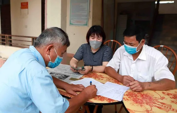 Chi trả tiền hỗ trợ cho người dân gặp khó khăn do Covid-19. Ảnh: TTXVN