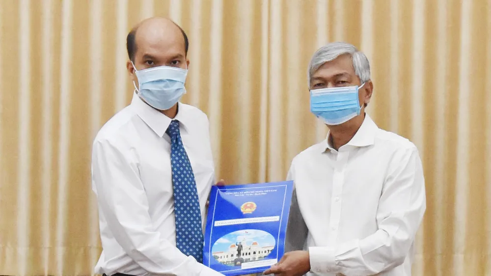 Phó Chủ tịch UBND TPHCM Võ Văn Hoan trao quyết định cho ông Nguyễn Nghĩa Hiệp. Ảnh: ĐÌNH LÝ