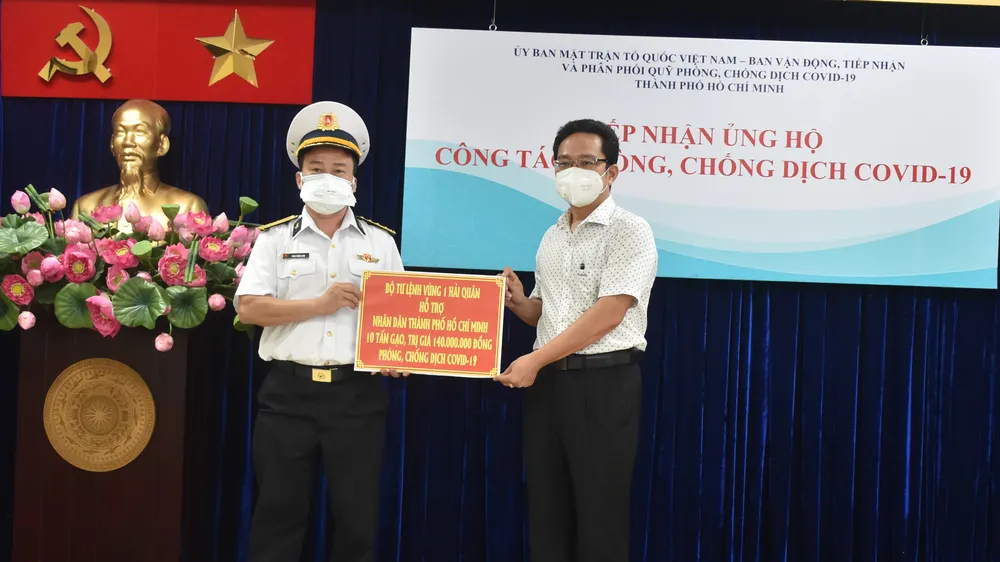 Ông Phạm Minh Tuấn tiếp nhận bảng tượng trưng ủng hộ 10 tấn gạo của Bộ Tư lệnh Vùng 1 Hải quân trao tặng