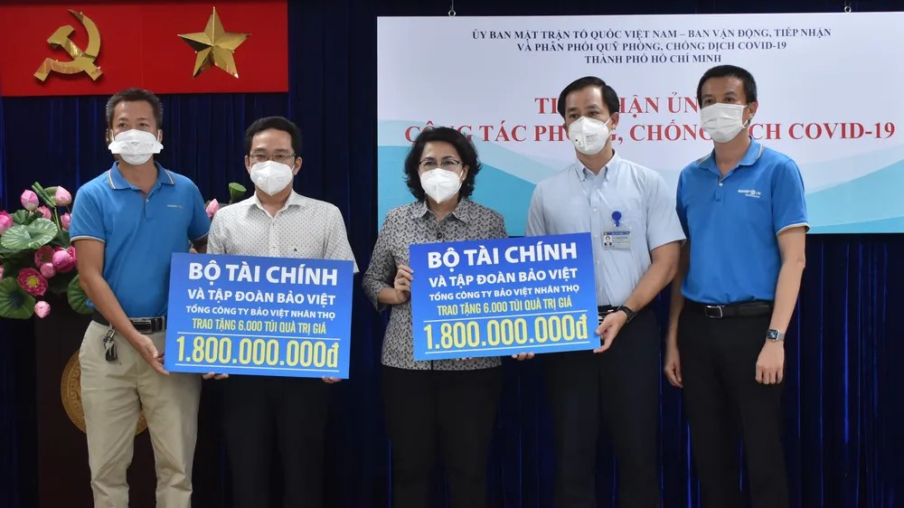 Chủ tịch Ủy ban MTTQ Việt Nam TPHCM Tô Thị Bích Châu tiếp nhận bảng tượng trưng ủng hộ từ đại diện Bộ Tài chính và Tập đoàn Bảo Việt