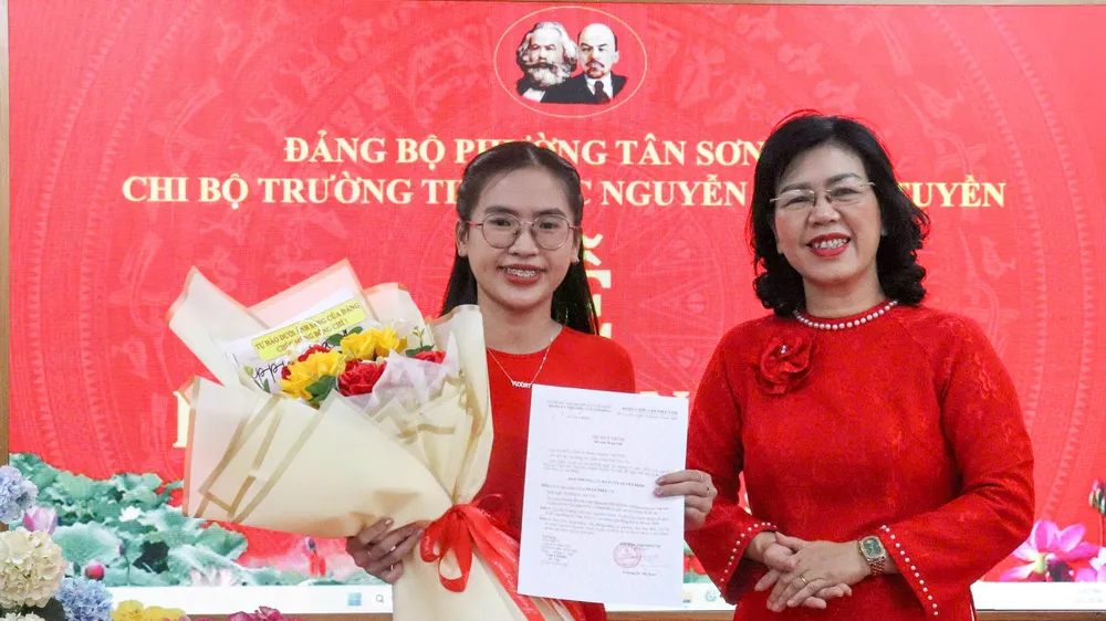 Đồng chí Trương Lê Mỹ Ngọc, Bí thư Đảng ủy phường Tân Sơn Hòa, trao Quyết định kết nạp đảng viên mới Trần Trúc Vy