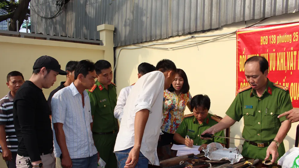 Nhiều người dân tới giao nộp hung khí để nhận quà. Ảnh: CHÍ THẠCH