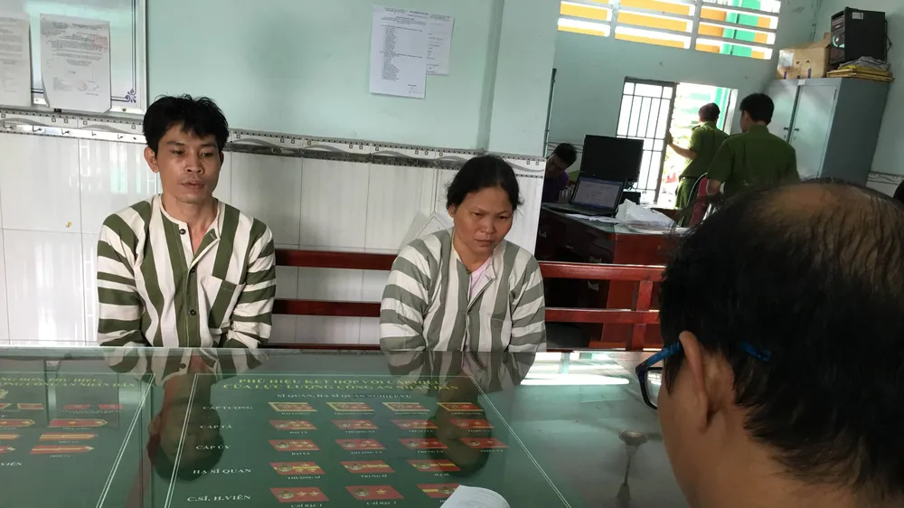 Công an lấy lời khai của cặp nam nữ dùng đá tấn công công an. Ảnh: CHÍ THẠCH