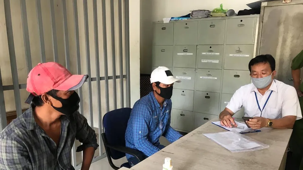 Lực lượng tiến hành xử phạt 2 thanh niên không đeo khẩu trang nơi công cộng. Ảnh: C.T