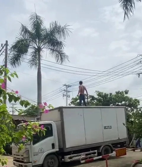 Người đàn ông nghi ngáo đá leo lên xe tải. Ảnh: VIẾT PHÓNG 