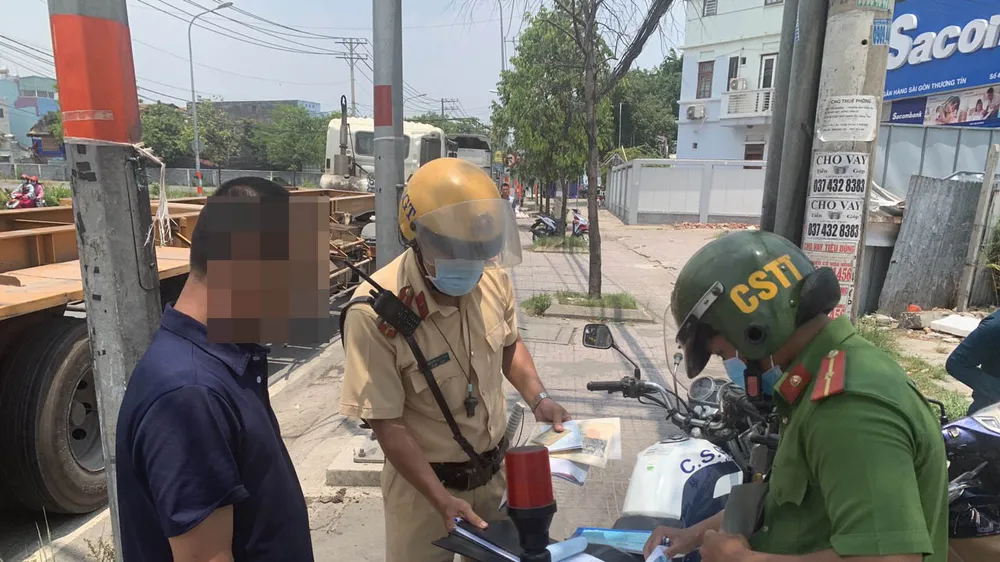 Lực lượng xử phạt một tài xế dừng đỗ ngay tại vòng xoay Phú Hữu. Ảnh: CHÍ THẠCH 