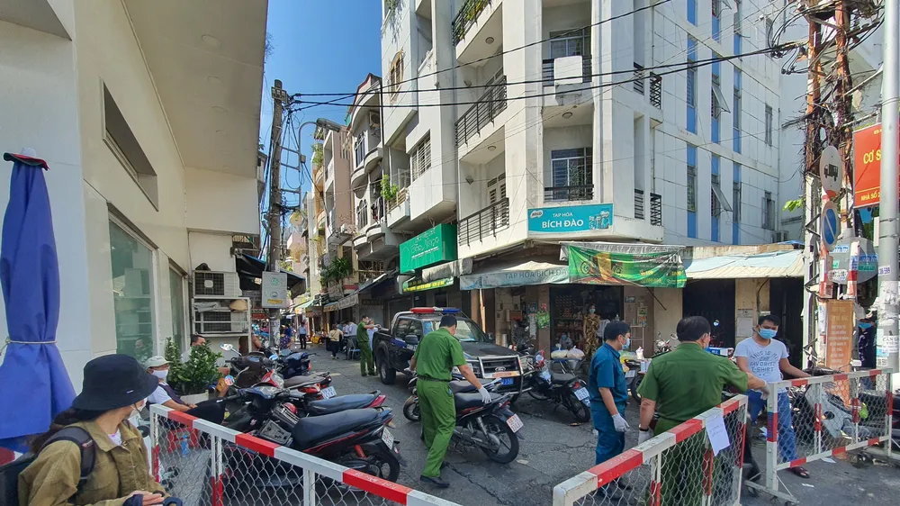 Lực lượng chức năng phong toả con hẻm có ca nghi mắc Covid-19. Ảnh: CHÂU TRỊNH 