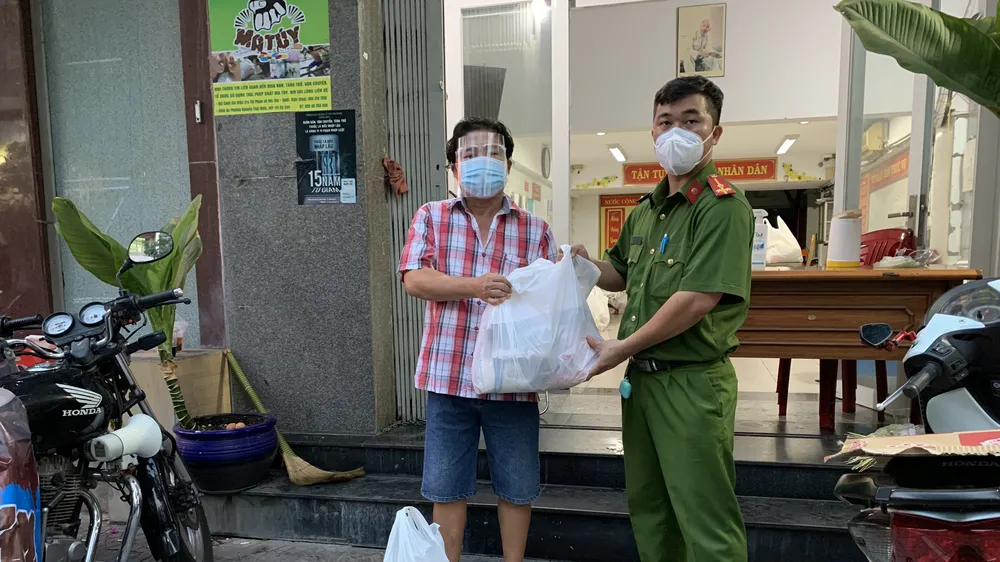 Thượng úy Vinh trao quà cho bà con. Ảnh: BẢO TRÂN
