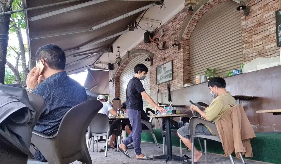 Nhiều khách ngồi tại bàn thoải mái uống cà phê nói chuyện không đeo khẩu trang. Ảnh: C.T