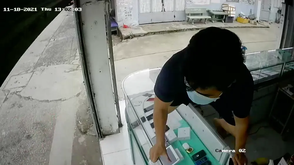 Chủ tiệm leo qua tủ kính truy đuổi thanh niên vờ mua rồi cướp điện thoại