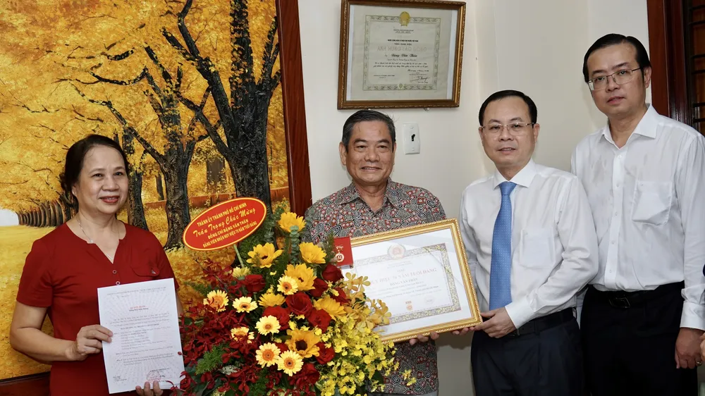 Phó Bí thư Thành ủy TPHCM Nguyễn Văn Hiếu trao Huy hiệu 70 năm tuổi Đảng cho đồng chí Đặng Văn Thân. Ảnh: HOÀNG HÙNG 