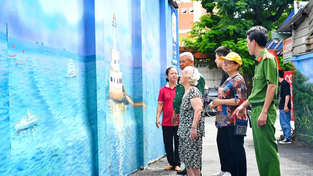 Người dân trong con hẻm bên mảng tường được sơn lại góp phần thay đổi cảnh quan