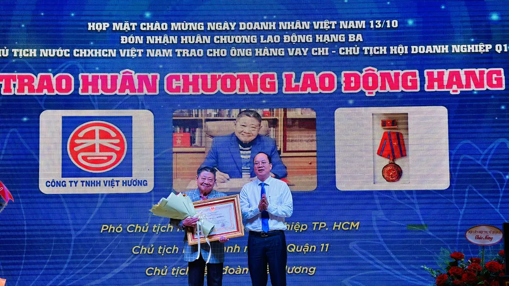 Phó Bí thư Thành ủy TPHCM Nguyễn Hồ Hải trao Huân chương lao động cho ông Hàng Vay Chi. Ảnh: CHÍ THẠCH